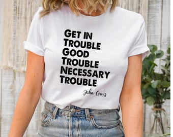 Pode incluir: Camiseta branca com texto preto que diz "Get in Trouble Good Trouble Necessary Trouble John Lewis".