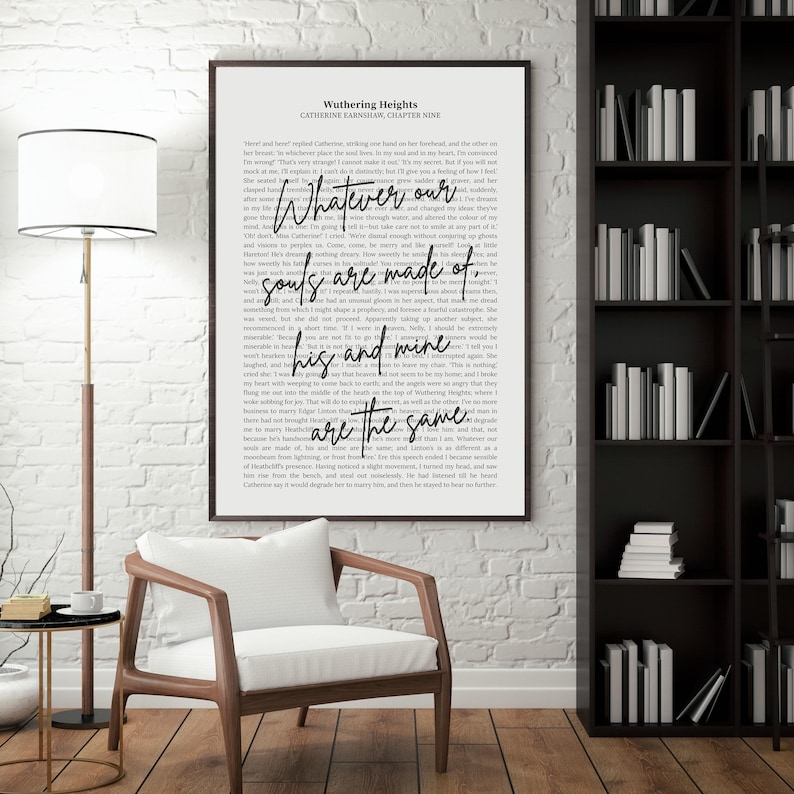 May include: A framed print of text from Wuthering Heights, with the quote "Whatever our souls are made of, his and mine are the same." The print is in a black frame, hanging on a white brick wall. A wooden chair and bookshelf are in the room.