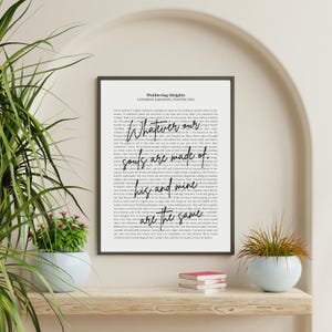 May include: A framed print of a page from "Wuthering Heights" by Catherine Earnshaw. The text includes the phrases "Whatever our souls are made of, his and mine are the same" in a decorative font. The frame is black.
