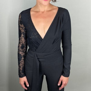 Sexy long sleeve black jumpsuit with deep v and lacy single sleeve and back by bebe