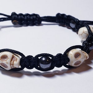 May include: Black cord bracelet with white skull beads and black beads.