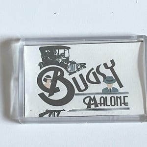 May include: A white rectangular keychain with a black and white image of a vintage car, two men in hats, and the text "Bugsy Malone".