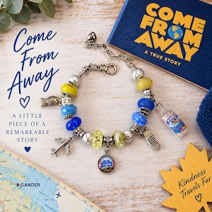 May include: A charm bracelet featuring a silver chain with colourful glass beads in yellow, blue, and green, interspersed with silver spacers. Charms include a miniature aeroplane, a fish, a mobile phone, a bottle labelled Screech, and a round Gander pendant.