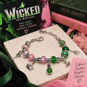 May include: A silver-tone charm bracelet featuring alternating pink and green beads, including faceted glass, solid, and patterned spheres. Charms include a star, a crown, a small bottle filled with green glitter, and a broomstick, with a lobster clasp.