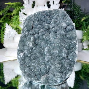 以下が含まれることがあります： 表面が粗くてざらざらした、大きな濃い緑色のアメジストのジオード。ジオードは、小さなキラキラ光る結晶で満たされています。