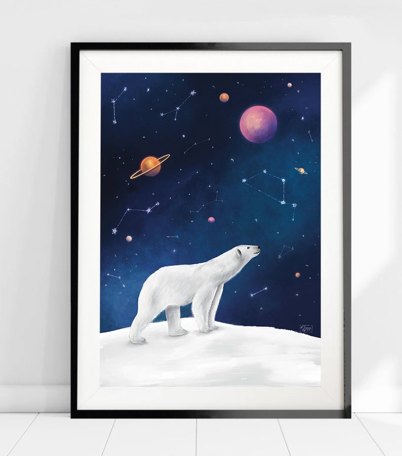 K&ouml;nnte beinhalten: Gerahmter Kunstdruck mit einem wei&szlig;en Eisb&auml;ren, der auf einer schneebedeckten Anh&ouml;he steht und in den Sternenhimmel blickt. Das Kunstwerk zeigt Sternbilder, Planeten und eine Farbpalette in Dunkelblau und Lila.