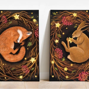 May include: Two framed illustrations of a fox and a hare sleeping in a wreath of branches with glowing stars. The fox is curled up in a ball, while the hare is holding a star in its paw. Both animals are surrounded by a dark background with red berries and leaves.