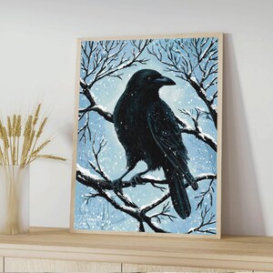 May include: A black crow perched on a bare branch in a snowy winter scene. The crow is facing right and has its wings folded. The background is a light blue with white snow falling.