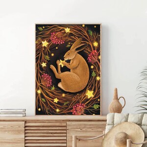 May include: A brown rabbit sleeps peacefully in a wreath of glowing lights and red berries against a dark background.