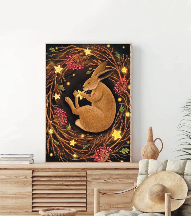 May include: A brown rabbit sleeps peacefully in a wreath of glowing lights and red berries against a dark background.