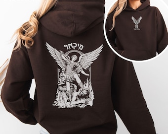 May include: Dark chocolate hoodie featuring a white graphic of an angel with outstretched wings and text. The hoodie has a drawstring hood and a front pocket. The text "DARK CHOCOLATE" is at the top left.