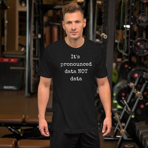 May include: A black t-shirt with white text that reads "It's pronounced data NOT data".