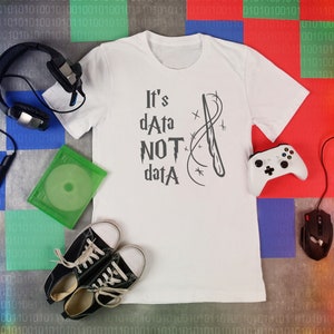 May include: White t-shirt with a graphic of two wands crossed with the text "It's dAta NOT datA" in a Harry Potter-inspired font.