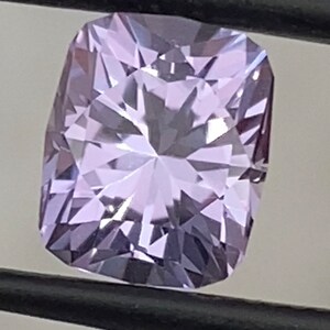 Op de afbeelding: Een lichtpaarse edelsteen met een kussen-slijpsel. De edelsteen is gefacetteerd en heeft een hoge mate van glans.