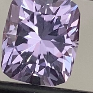 Op de afbeelding: Een lichtpaarse edelsteen met een kussen-slijpvorm. De edelsteen is gefacetteerd en heeft een hoge glans.