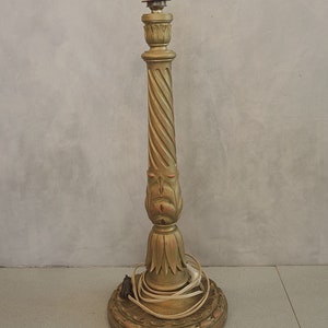 May include: A gold-painted wooden table lamp with a twisted column and a decorative base. The lamp has a simple, classic design.