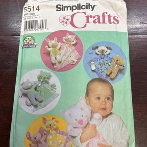 May include: A Simplicity 5514 sewing pattern envelope for stuffed animal security blankets. The front features illustrations of various plush animal designs, including cats, bears, and dogs, alongside a child holding a cat-themed blanket.