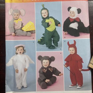 May include: Simplicity sewing pattern number 2506 for costumes for toddlers. The pattern includes five different costumes: a mouse, a dinosaur, a panda, an angel, and a devil. The pattern is for sizes A 1/2, 1, 2, 3, and 4.