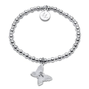 Peut inclure: Un bracelet élastique composé de perles argentées brillantes, agrémenté d'une breloque ronde gravée des lettres LL et d'une breloque en forme de papillon portant l'inscription Mum suivie d'un x. Les perles sont petites, polies et réfléchissantes.