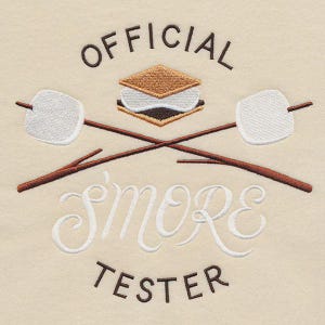 May include: Embroidered design on a cream-colored background. The design features the words "OFFICIAL S'MORE TESTER" in brown and white script. A s'more and two crossed marshmallow roasting sticks complete the design, perfect for camping enthusiasts.