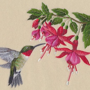 May include: Embroidered image of a hummingbird with iridescent wings, a red throat, and green head, approaching a cluster of vibrant pink fuchsia flowers. The flowers have long, white-tipped stamens and are set against a beige background.