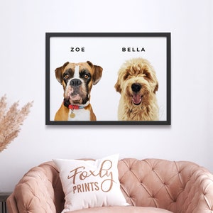 May include: A framed print featuring two dogs, a brown and white Boxer named Zoe and a golden doodle named Bella. The print has a black frame and white background with the dog's names printed in black text.