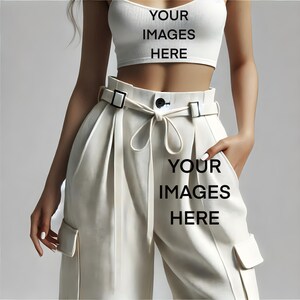 May include: White high-waisted pants with a wide belt and a tie detail. The pants have cargo pockets on the sides.