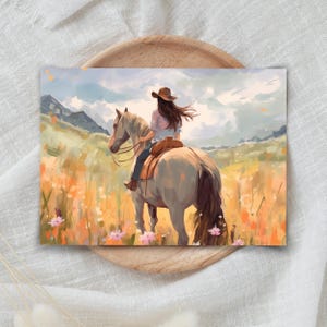 May include: An artistic print depicting a person on horseback in a field of wildflowers. The rider, viewed from behind, wears a brown hat. The horse is light grey, and the scene is set against mountains and a cloudy sky.