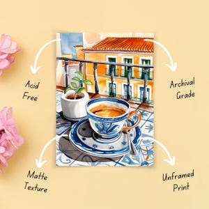 May include: A watercolor painting of a cup of coffee on a tiled balcony overlooking a colorful building. The cup is blue and white with a floral design. The building is yellow with red tile roof. The painting is printed on archival grade, acid-free matte paper.