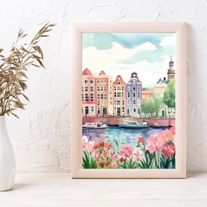 May include: Watercolor painting of colorful buildings lining a canal with boats and flowers in the foreground. The buildings have red, orange, yellow, blue, and green accents. The sky is a light blue with white clouds.