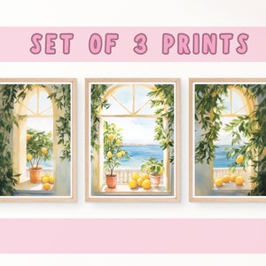 May include: Set of three watercolor prints featuring a window view of a lemon tree and the ocean. The prints are framed in natural wood.