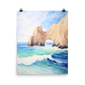 May include: A vertical wall art print featuring a watercolor painting of a natural rock arch formation rising from the ocean. The scene depicts light blue water with white crashing waves in the foreground and a bright sky above the cliffs.