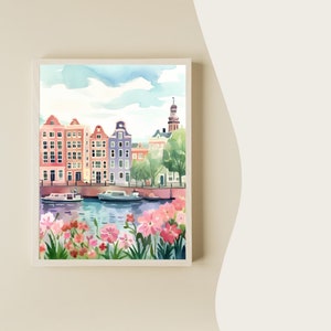 May include: Watercolor painting of a canal scene in Amsterdam, Netherlands. The painting features colorful buildings, a canal with boats, and a lush green tree. The sky is blue with white clouds. Pink flowers are in the foreground.