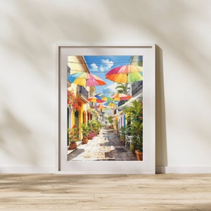 May include: A colourful street scene with a row of rainbow umbrellas hanging over a cobbled walkway lined with buildings. The buildings are painted in shades of yellow and have green plants growing on the walls.