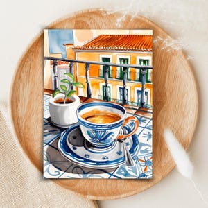 May include: A watercolor painting of a cup of coffee on a blue and white patterned saucer with a spoon. The cup is sitting on a tiled balcony overlooking a yellow building with green shutters.