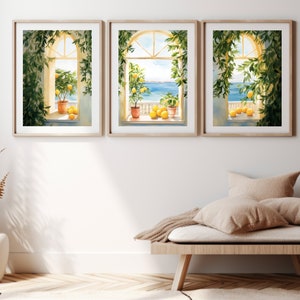 May include: Three framed watercolor paintings of windows with views of the ocean. Each window is framed by lush green vines and features a potted lemon tree with ripe lemons. The windows are set against a white wall.