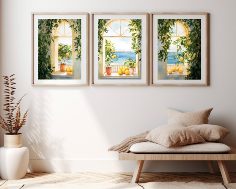 May include: Three framed watercolor paintings of windows with views of the ocean. Each window is framed by lush green vines and features a potted lemon tree with ripe lemons. The windows are set against a white wall.
