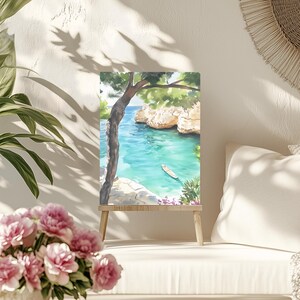 May include: Watercolor painting of a coastal scene with turquoise water, a small boat, and rocky cliffs. A tree frames the view, and the artwork is displayed on a small wooden easel. The painting evokes a sense of tranquility and natural beauty.