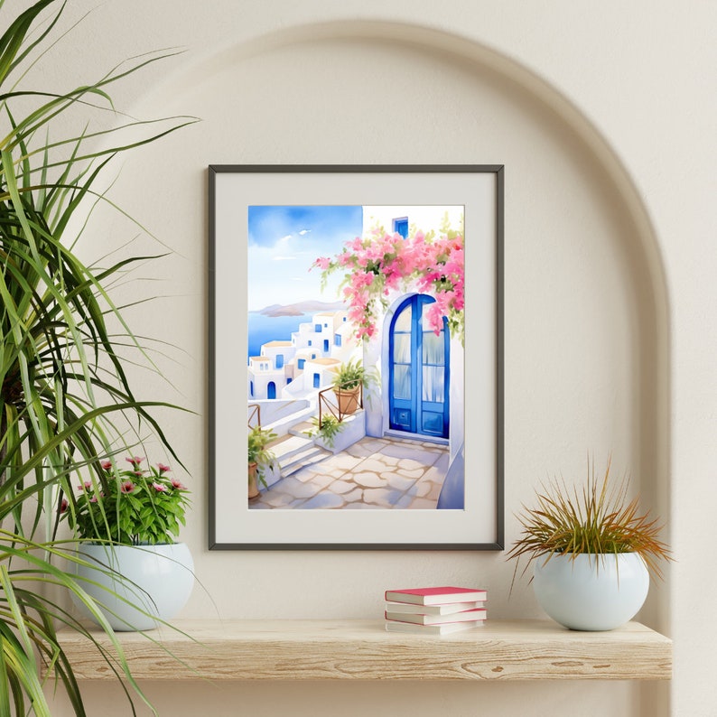 May include: A framed wall art print depicting a Mediterranean coastal scene with white buildings, a bright blue arched door, and vibrant pink bougainvillea flowers. The artwork features a stone pathway leading toward a sea view under a clear blue sky.