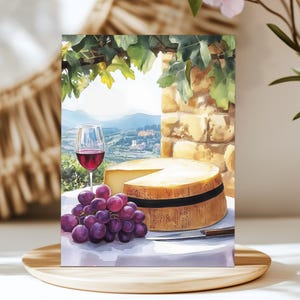 May include: Watercolor painting of a wine and cheese still life. A glass of red wine, a wheel of cheese, and a bunch of purple grapes are on a white tablecloth. A knife rests beside the cheese. The background shows a scenic view.