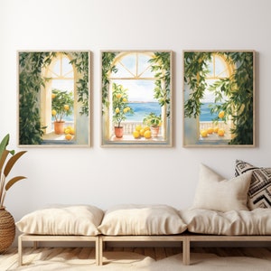 May include: Three framed watercolor paintings of windows with views of the ocean and lemon trees. The windows are framed in wood and the paintings are set against a white wall.