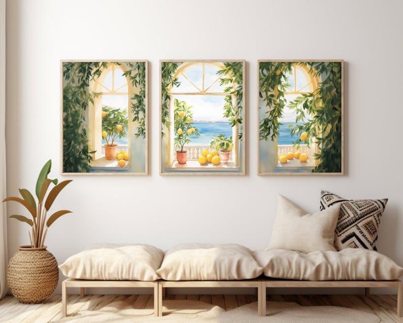 May include: Three framed watercolor paintings of windows with views of the ocean and lemon trees. The windows are framed in wood and the paintings are set against a white wall.