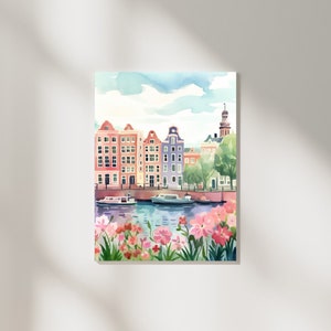 May include: A watercolor painting of a canal scene in a European city. The painting features colorful buildings, boats, and flowers in shades of pink, red, and green.