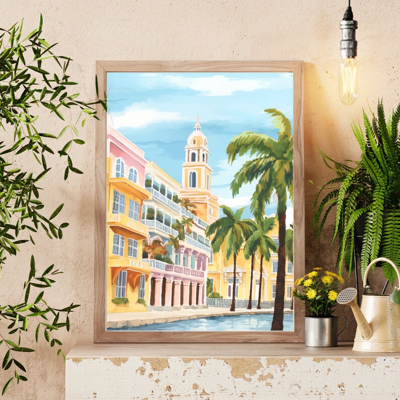Peut inclure: Une peinture encadr&eacute;e d'une ville color&eacute;e avec des palmiers et un canal. Les b&acirc;timents sont jaunes, roses et blancs avec des balcons et des arches. Le ciel est bleu avec des nuages blancs.