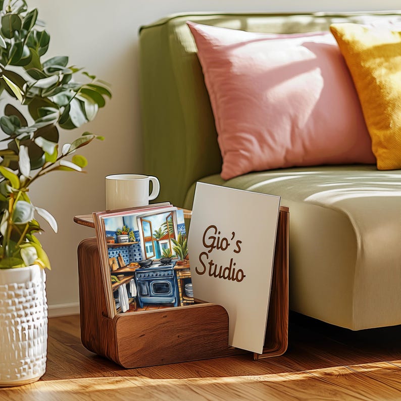 May include: A wooden magazine rack with a white card that says "Gio's Studio" and a stack of colorful postcards featuring a kitchen scene.