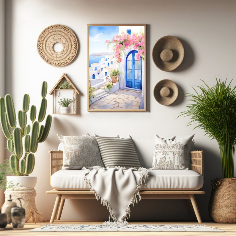 May include: A framed watercolor-style print depicting a Mediterranean coastal scene with white buildings, a bright blue arched door, and pink bougainvillea flowers, displayed on a wall above a light-colored wooden bench with cushions.