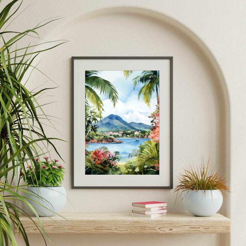 May include: A framed watercolor painting of a tropical island scene. The painting depicts a lush green island with a blue lagoon and a mountain in the background. The painting is framed in a dark gray frame and is hanging on a white wall.