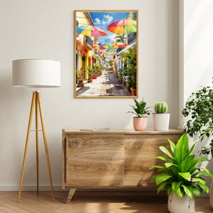 May include: A colourful painting of a narrow street lined with buildings and colourful umbrellas overhead. The street is paved with cobblestones and there are plants and flowers in pots along the sides of the street.