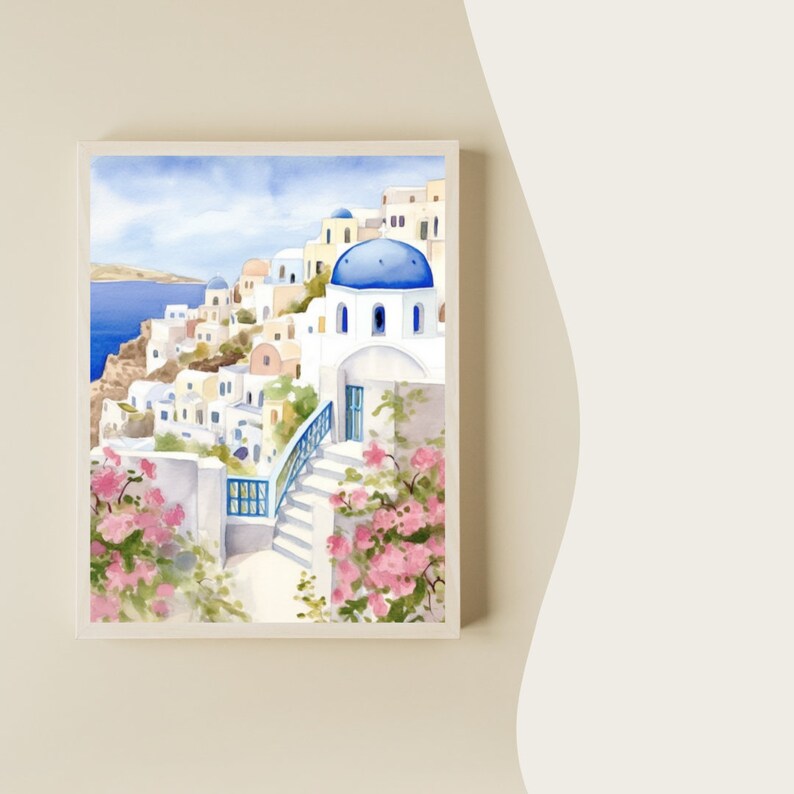 Puede incluir: Una pintura en acuarela enmarcada que representa un pueblo costero con edificios blancos, techos de c&uacute;pula azul y escaleras de piedra. La escena incluye flores de buganvilla rosa vibrantes en primer plano y el mar azul profundo.