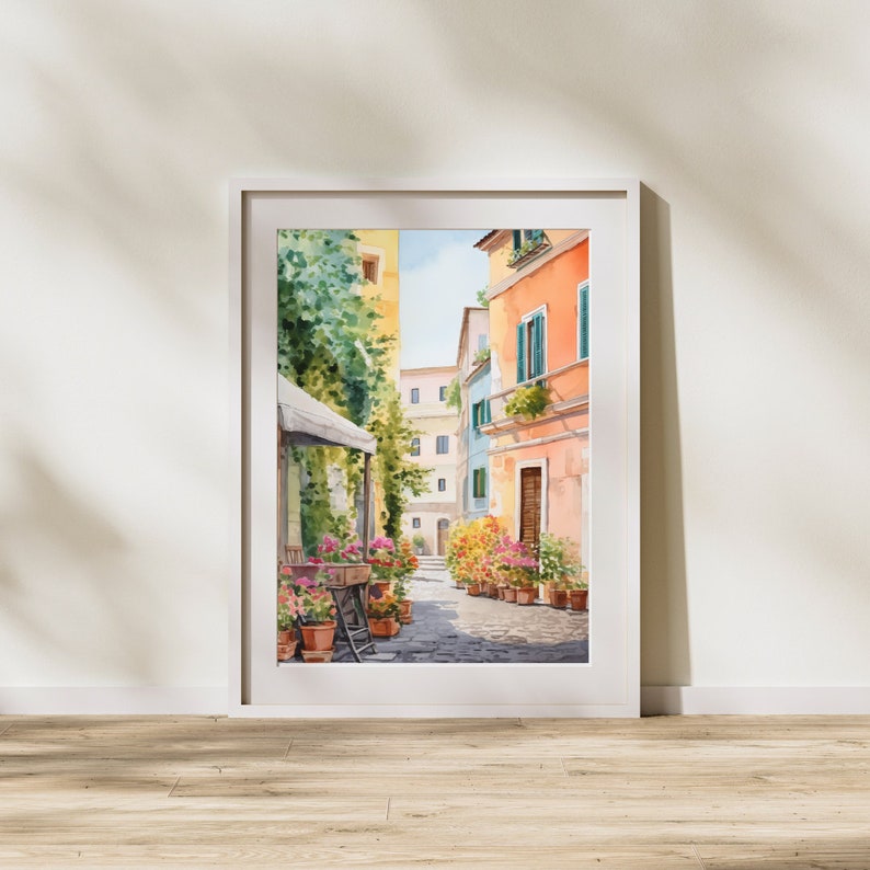May include: Watercolor painting of a narrow street in a European city. The street is lined with colorful buildings and potted plants. The painting is framed in a white frame.